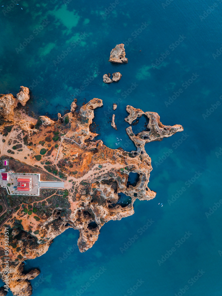 Fototapeta premium An aerial top down view of Ponte da piedade in Lagos, Algarve, Portugal. Showing the lighthouse and the atlantic ocean.