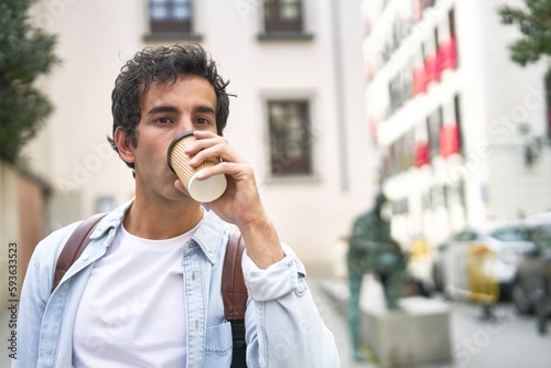 Young man kicks off his busy day with a refreshing takeout coffee on his way to work in the city.