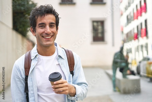 Young man kicks off his busy day with a refreshing takeout coffee on his way to work in the city.