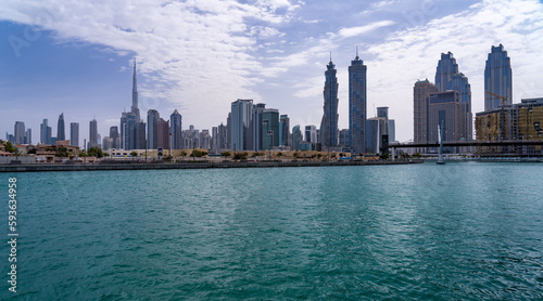 Low rise family homes alongside Dubai Canal with apartment blocks of downtown district behind