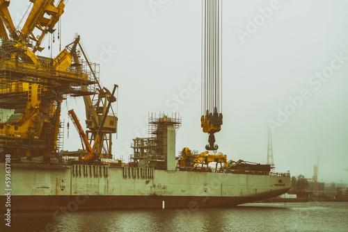 Statek dźwig do montażu instalacji wiatrowych na morzu w mglisty dzień. photo
