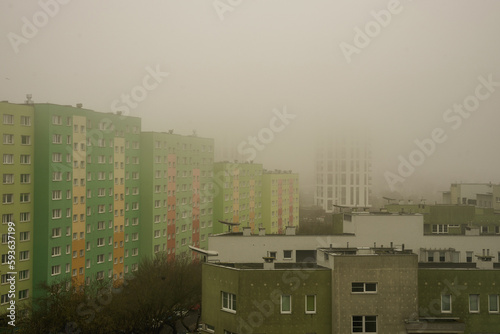 Gęsty smog w mieście. Budynki mieszkalne w mgle. 