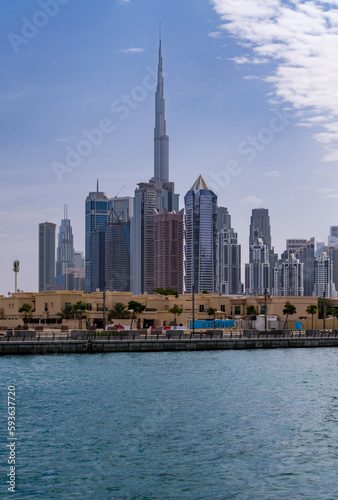Low rise family homes alongside Dubai Canal with apartment blocks of downtown district behind
