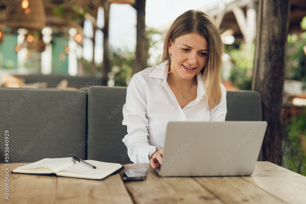 Female copywriter typing on laptop while sitting in cafe Female copywriter typing on laptop while sitting in cafe