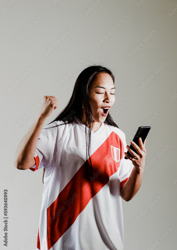 Naklejka premium Photograph of Peruvian fan woman celebrating a goal of her team. Concept of people, emotions and sports.
