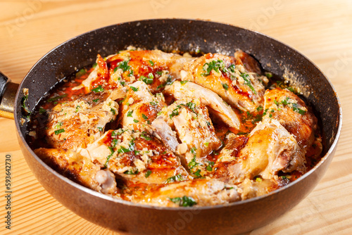 Shkmeruli, chicken in garlic sauce on a frying pan