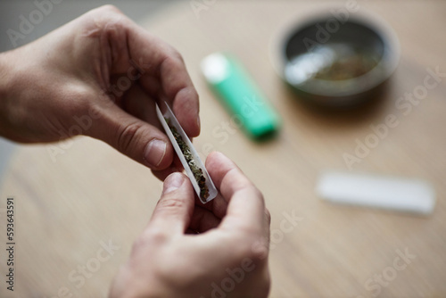 Closeup of male hands rolling up marijuana joint for therapeutic purpose and medical treatment  copy space