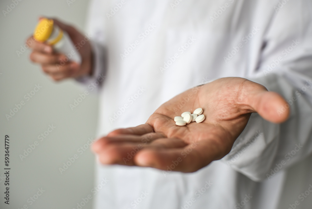 Pills in doctor's hand, white background Pills in doctor's hand, white background