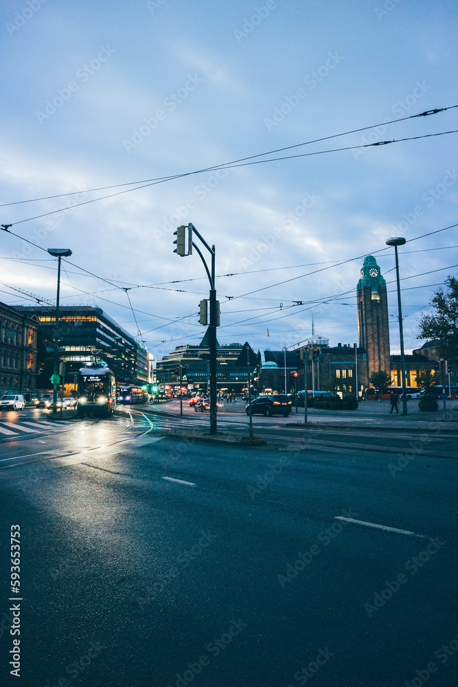 Look of tram train passing by aligned wiht buildings over sunset in stormy night helsinki 