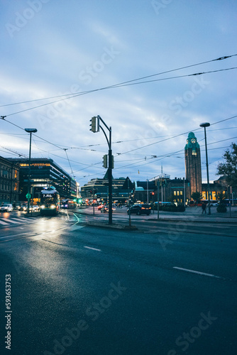 Look of tram train passing by aligned wiht buildings over sunset in stormy night helsinki 