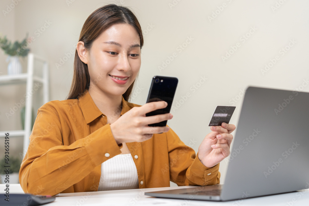 Convenience online internet banking, smile asian young woman hand in holding credit card to payment spending by scan qr code to transfer or pay money without cash at home. Technology of financial.