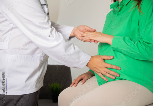A gynecologist counts the movements of the fetus in the abdomen of a pregnant girl. The activity of the baby in the womb, close-up