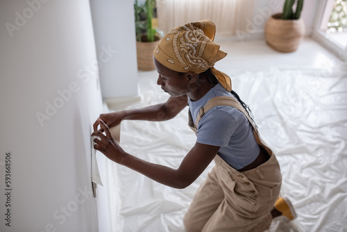 Black woman attaching protective tape to socket photo