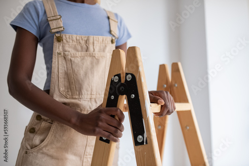 Crop black painter touching ladder