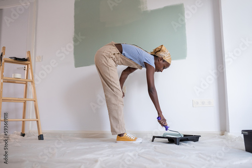 Black woman preparing to paint wall