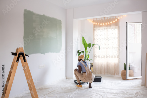 Black woman preparing paint for wall