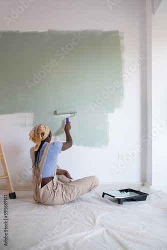 Unrecognizable black woman changing wall color