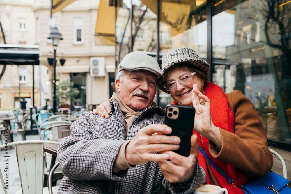 Senior Couple Talking on Video Call in Cafe Senior Couple Talking on Video Call in Cafe