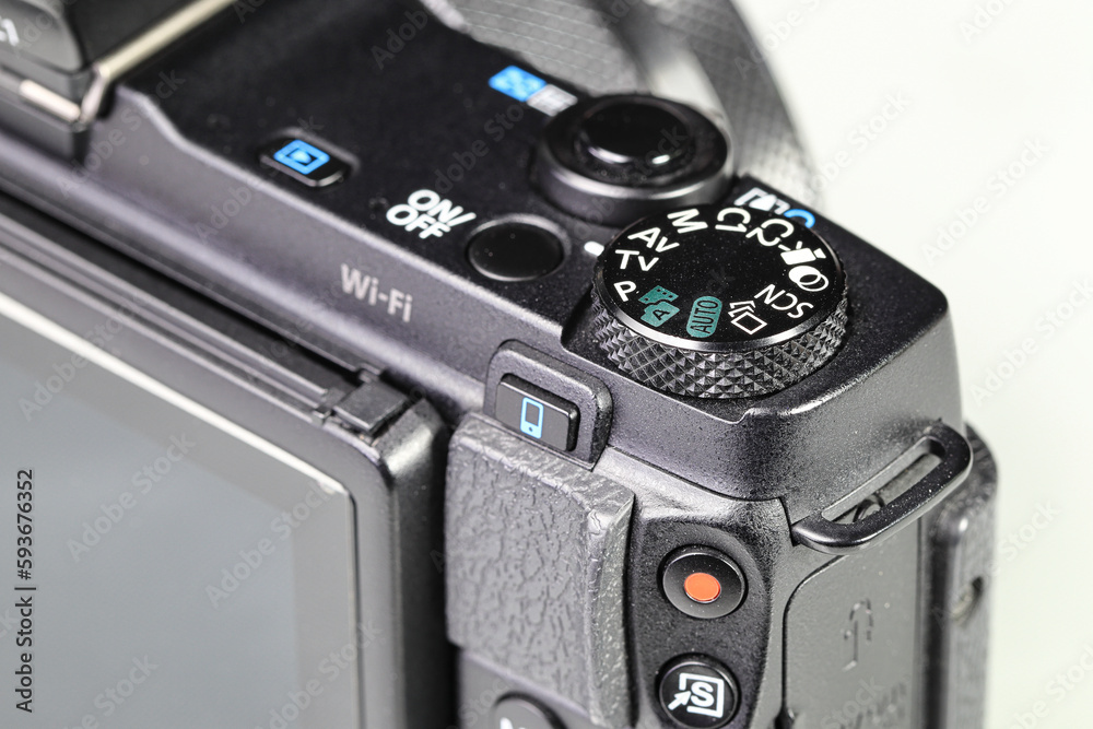 Close up top panel of hi-end compact Digital Camera, Mirrorless Digital Camera, show on camera mode command functional dial, on-off button, shutter, Video record, multi function button.