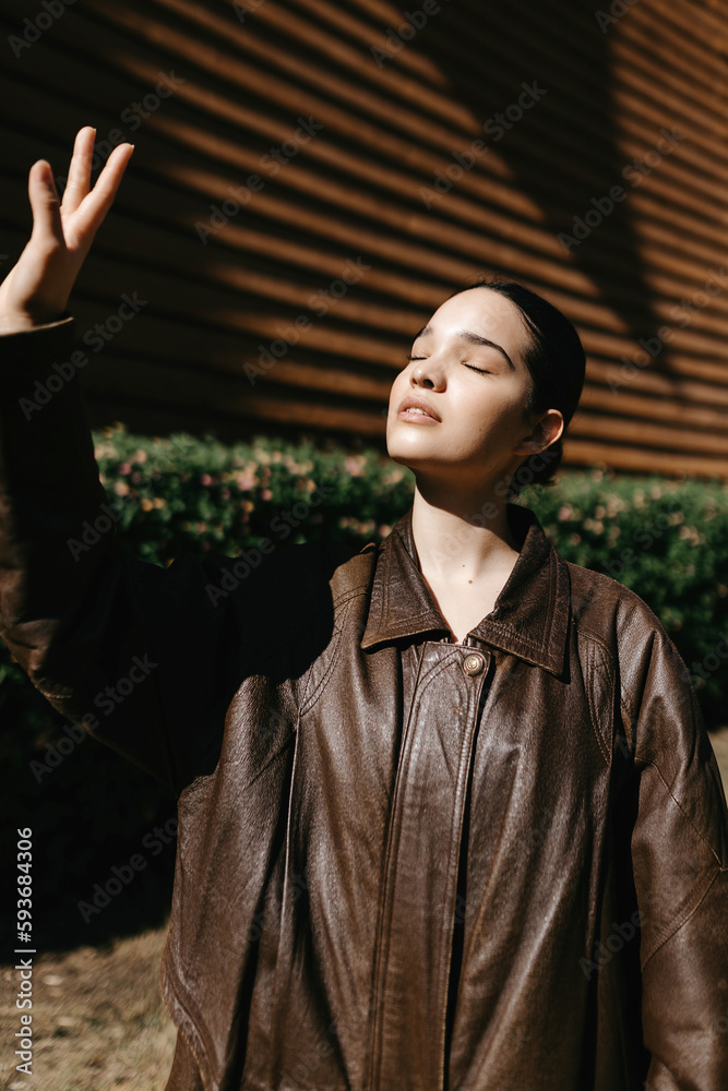 Dreamy woman with raised hand in sunlight