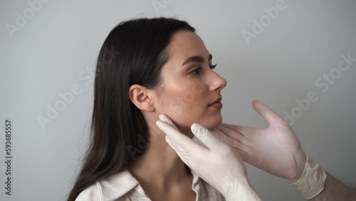 4k video Rhinoplasty is reshaping nose surgery for change appearance of the nose and improve breathing. ENT doctor is touching nose and consulting girl patient before septoplasty surgery.