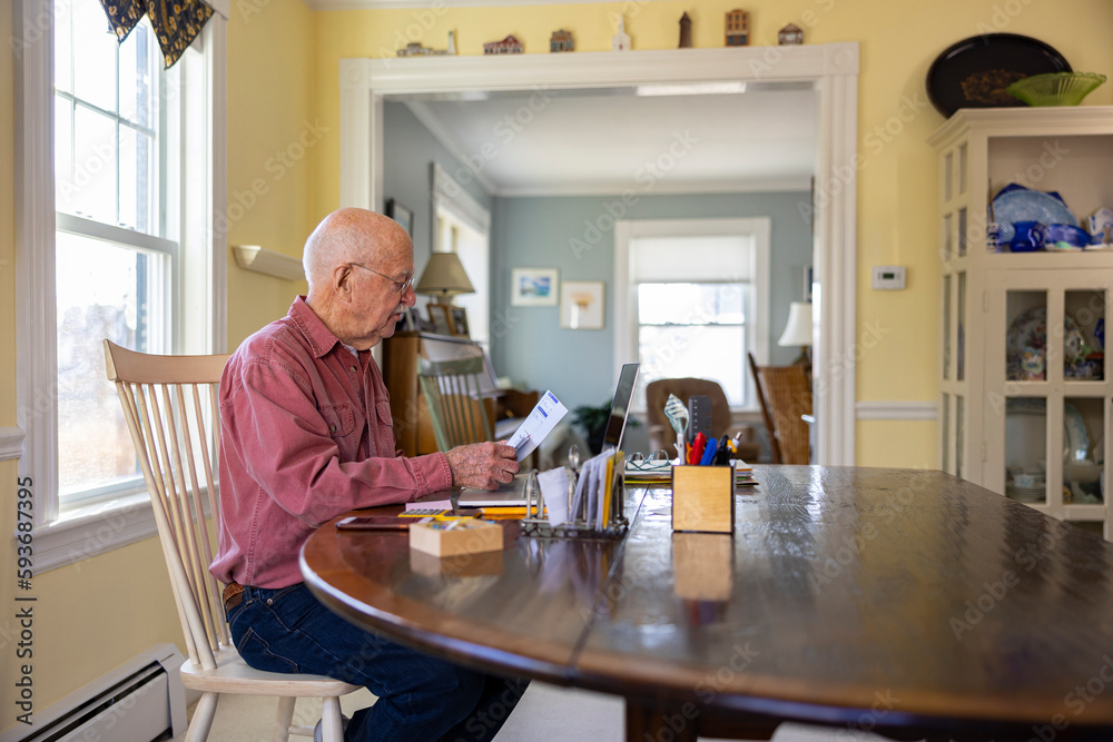 Senior Man at Home Paying bills with laptop computer Senior Man at Home Paying bills with laptop computer