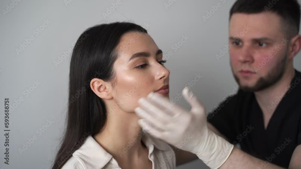4k video Rhinoplasty is reshaping nose surgery for change appearance of the nose and improve breathing. ENT doctor is touching nose and consulting girl patient before septoplasty surgery. 4k video Rhinoplasty is reshaping nose surgery for change appearance of the nose and improve breathing. ENT doctor is touching nose and consulting girl patient before septoplasty surgery.