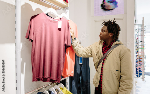 Young guy looking at clothes in a shop