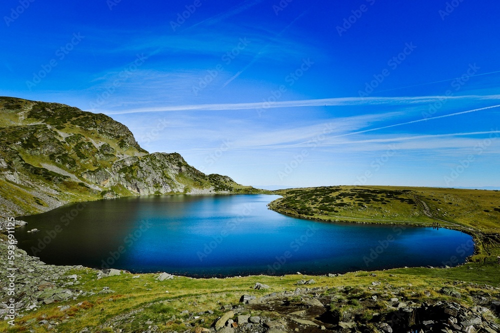 Seven Rila lakes view with green fields and mountains around, clear sky background
