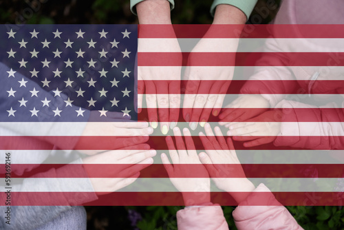 Hands of kids on background of USA flag. American patriotism and unity concept.