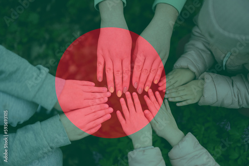 Hands of kids on background of Bangladesh flag. Bangladeshi patriotism and unity concept. photo