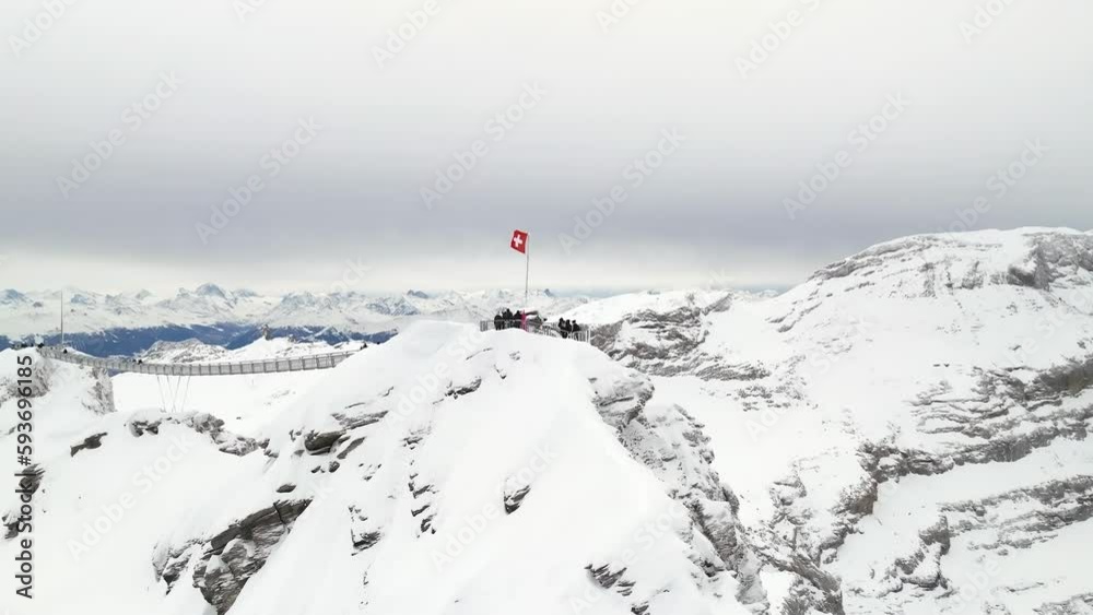 Swiss flag over a peak walk in the alps aerial view by drone Swiss flag over a peak walk in the alps aerial view by drone
