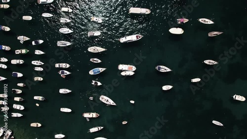 Aerial video of boats, yacht, docked in harbor tropical clear green water sea.
