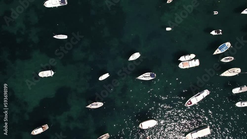Aerial video of boats, yacht, docked in harbor tropical clear green water sea.
