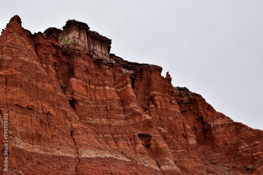 Red steep sandstone formations in Palo Duro Canyon State Park in Texas