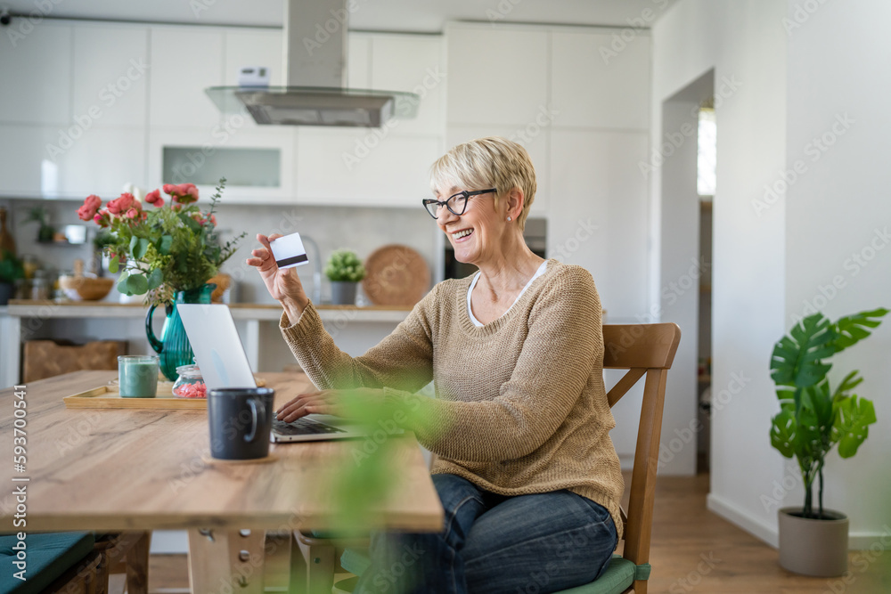 Senior woman caucasian female hold credit card online shopping at home Senior woman caucasian female hold credit card online shopping at home
