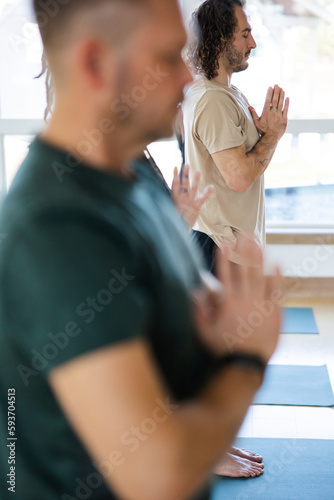 Meditative group yoga class practice inside modern studio. photo