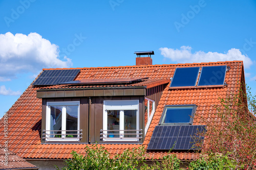 Rotes Hausdach mit Solarkollektoren zur Strom- und Warmwassererzeugung
