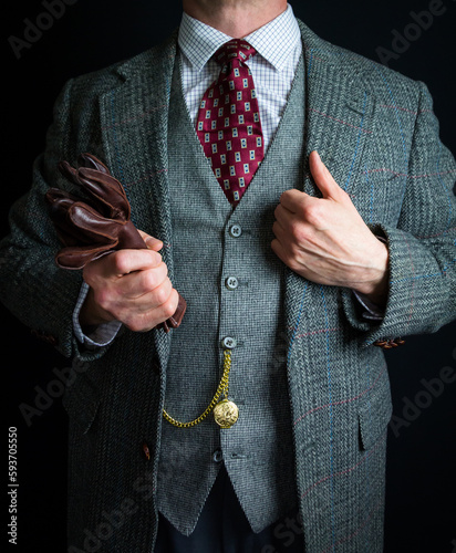 Portrait of Elegant Man in Tweed Suit Holding Leather Gloves in Carefree Attitude. Vintage Style and Elegant Fashion of Classic British Gentleman.