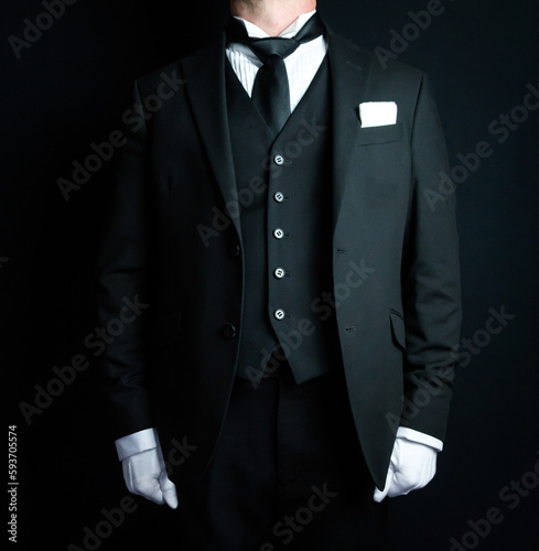 Portrait of Elegant Butler in Dark Formal Suit and White Gloves Standing at Attention. Service Industry and Professional Hospitality.