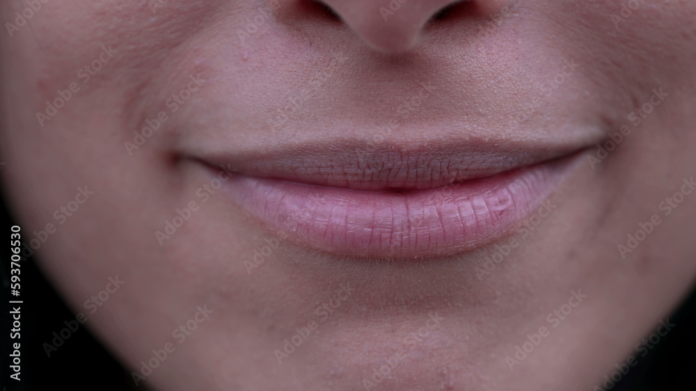 Fototapeta premium Macro closeup of a woman mouth smiling. Extreme close up of adult girl lips and teeth with happy expression