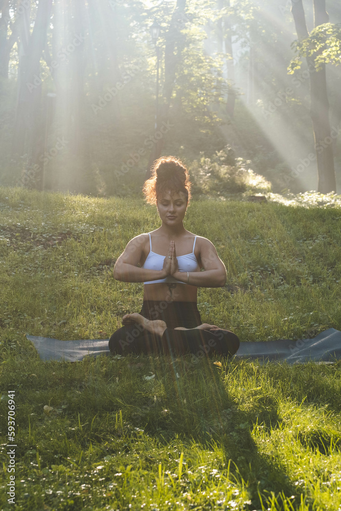 Young beautiful woman practise yoga at sunrise in park.
Young beautiful woman practise yoga at sunrise in park.