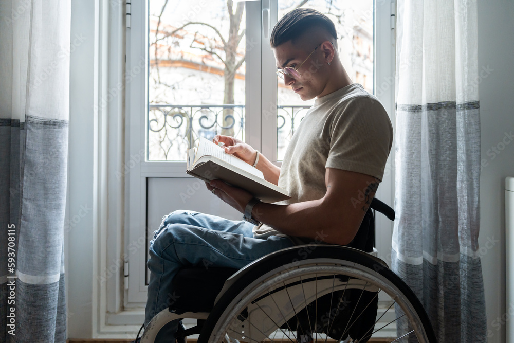 Young Man With A Disability Reading A Book Young Man With A Disability Reading A Book