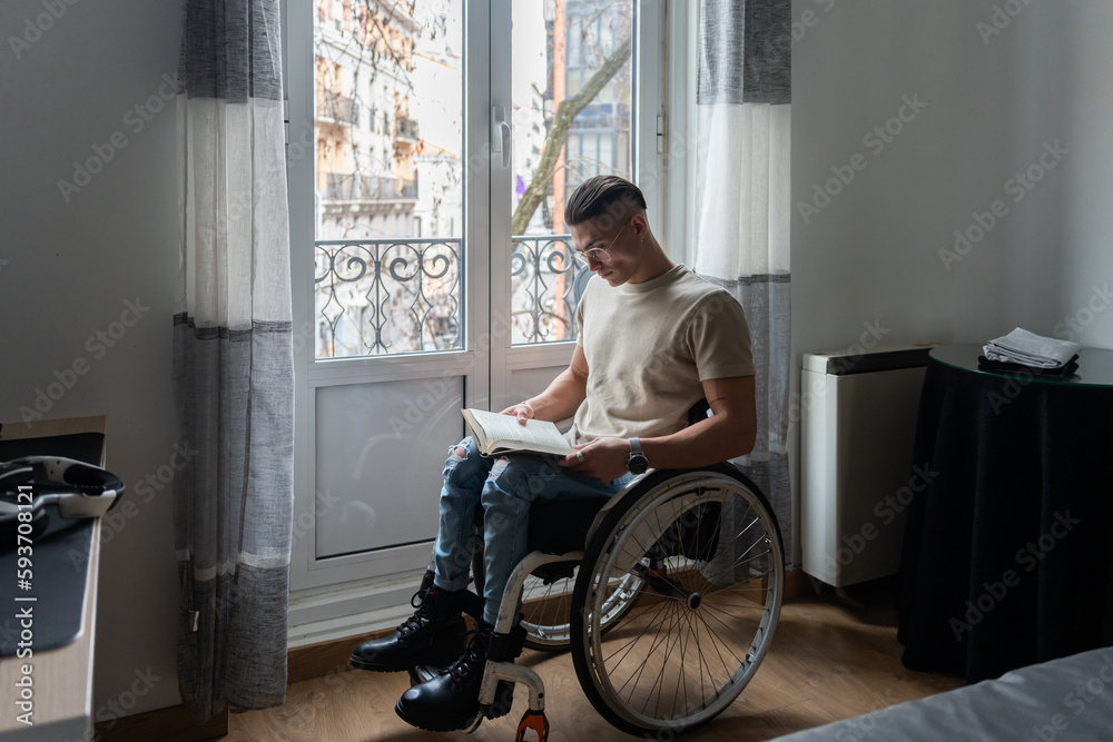 Young Man With A Disability Reading A Book Young Man With A Disability Reading A Book
