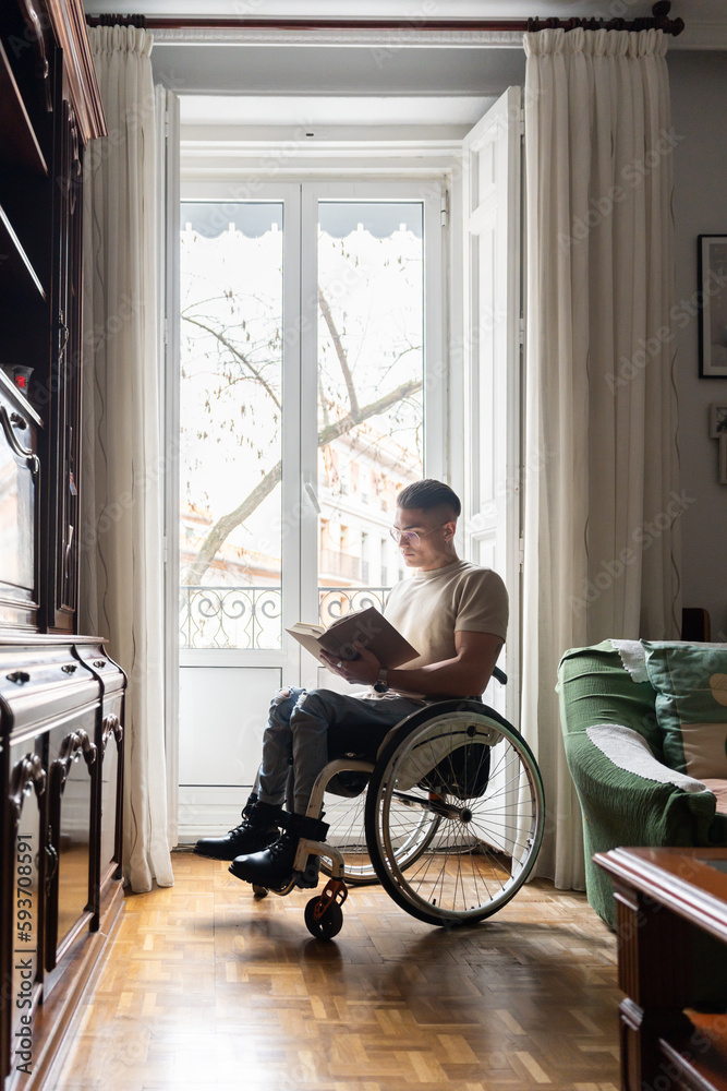 Young Man With A Disability Reading A Book Young Man With A Disability Reading A Book
