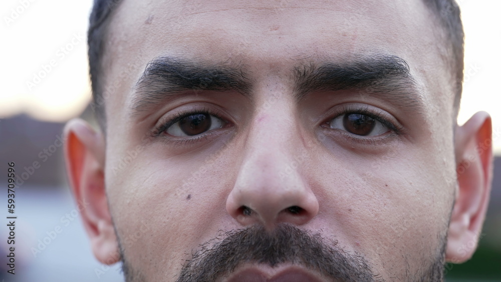 Obraz premium One Middle Eastern man portrait eyes looking at camera with serious expression. Arab male person close up eyes