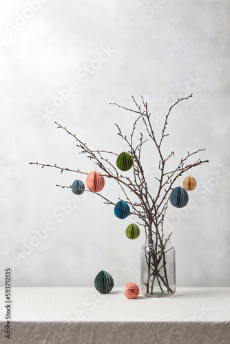 Colorful paper Easter eggs hung on tree branches. photo