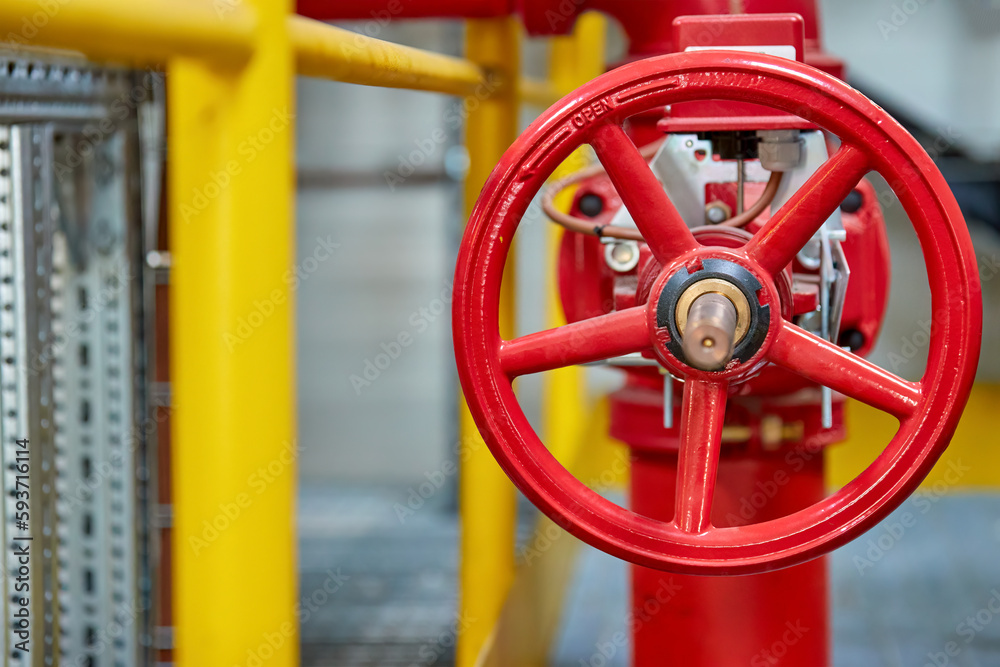 Red fire water valve on the piping system of the industrial firefighting system in the technological complex. Components of automatic fire extinguishing system. Red fire water valve on the piping system of the industrial firefighting system in the technological complex. Components of automatic fire extinguishing system.