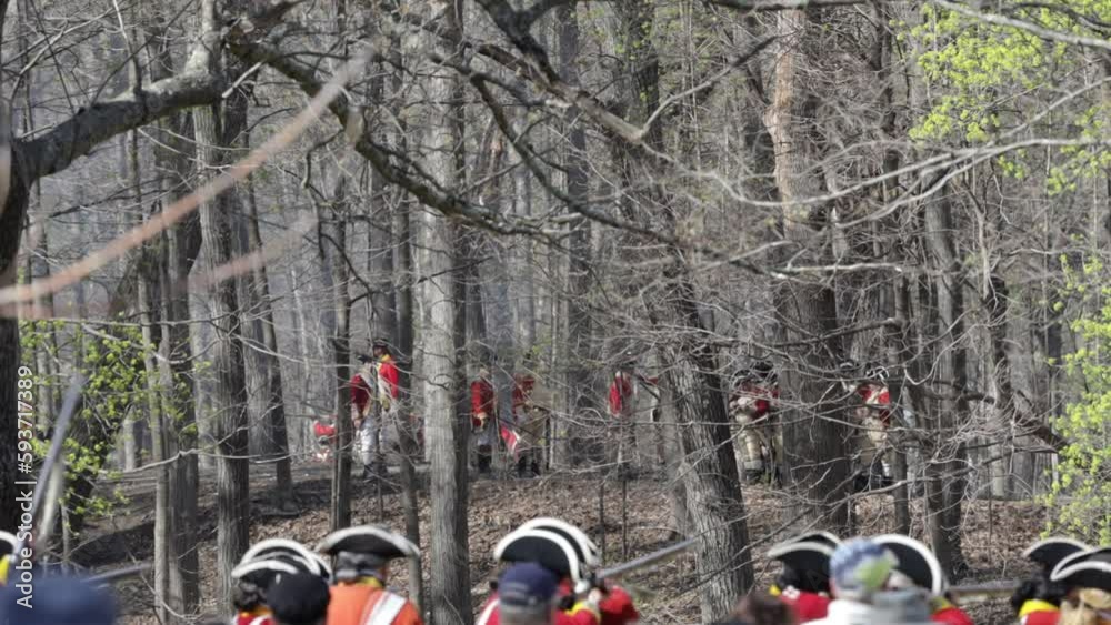 Tower Park, Lexington, MA, USA - April 15, 2023: Men dressed as 18th century British soldiers (redcoats) reenact one of the first battles of the American revolution as part of annual celebration.