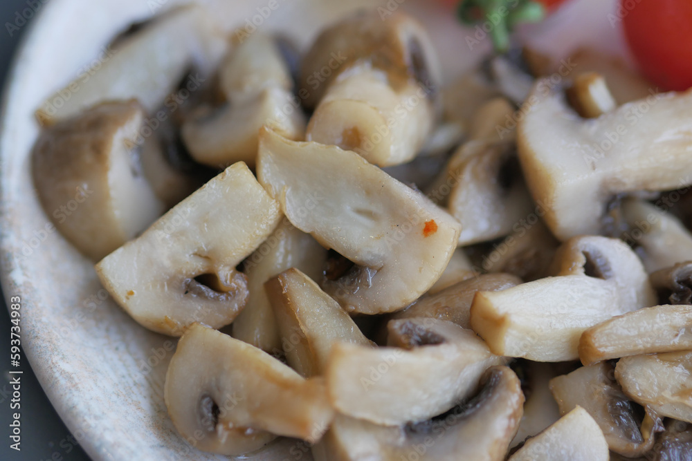sauteed mushrooms with garlic and parsley on a black plate on white background sauteed mushrooms with garlic and parsley on a black plate on white background